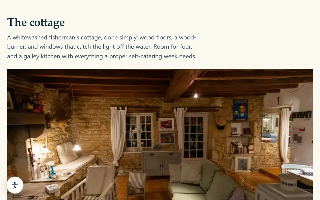 The holiday let demo's cottage page, showing a beamed living room with a wood-burner and a galley kitchen