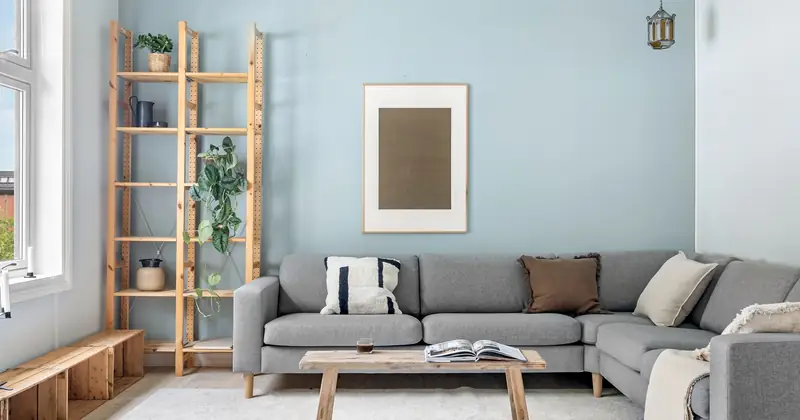 A cozy Scandinavian living room with modern gray couch and wooden elements.