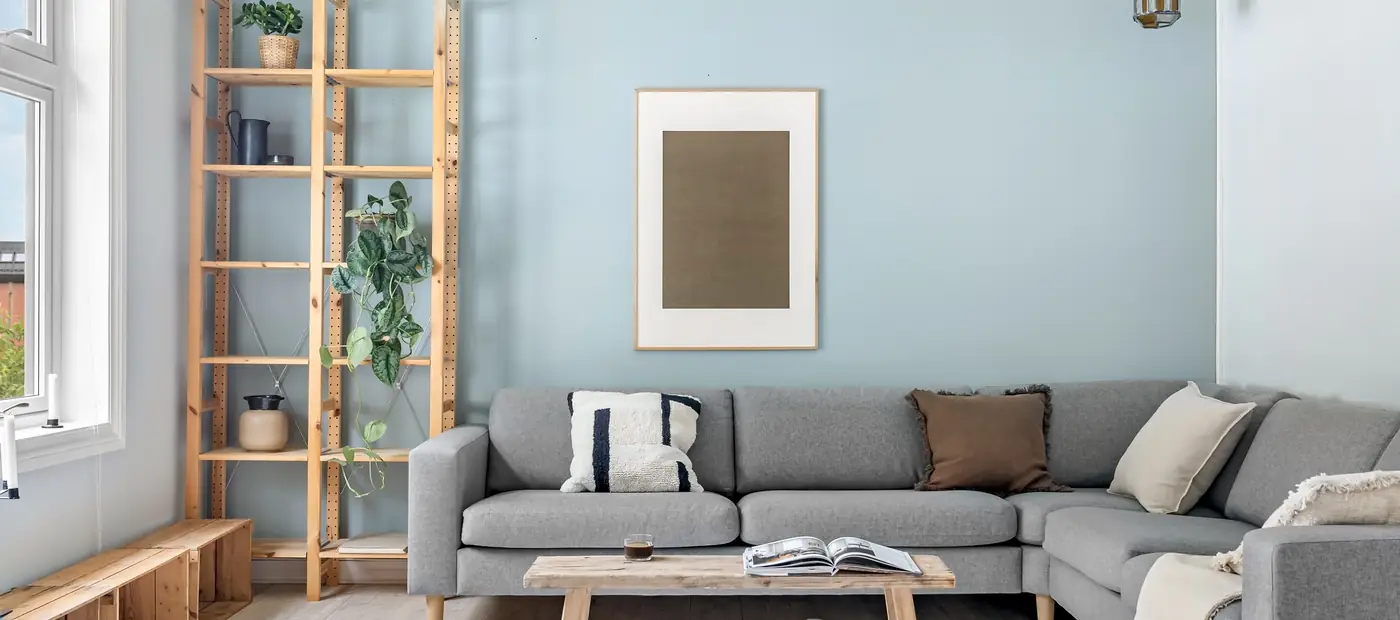 A cozy Scandinavian living room with modern gray couch and wooden elements.