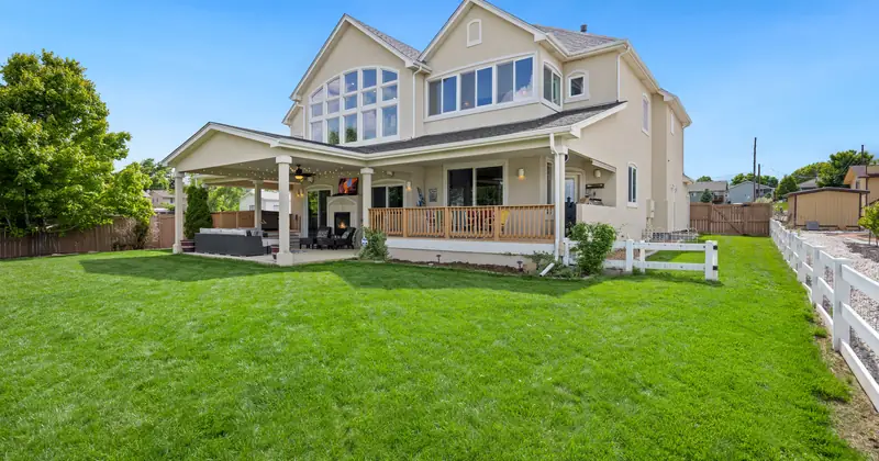 Beautiful two-story suburban house with a large green lawn and porch.