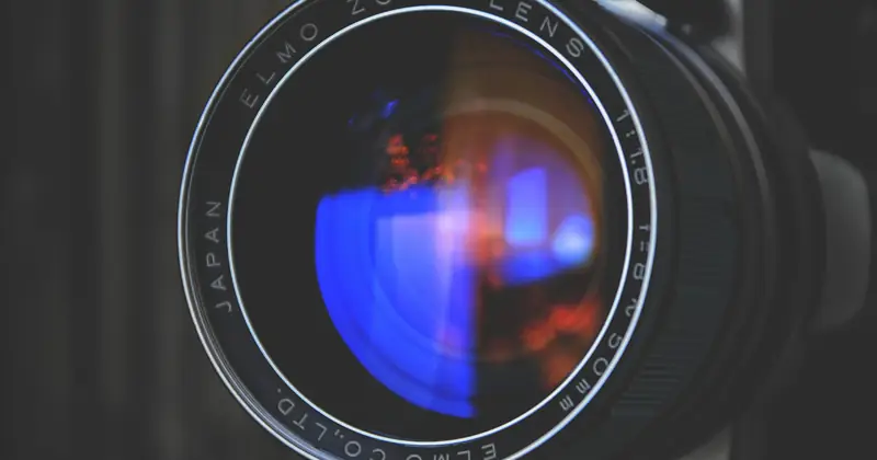 Detailed close-up of an Elmo zoom camera lens capturing vivid reflections. Perfect for photography enthusiasts.