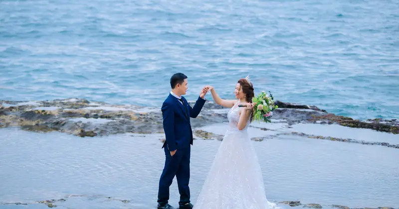 Elegant couple in outdoor pre-wedding photoshoot with flowing veil.