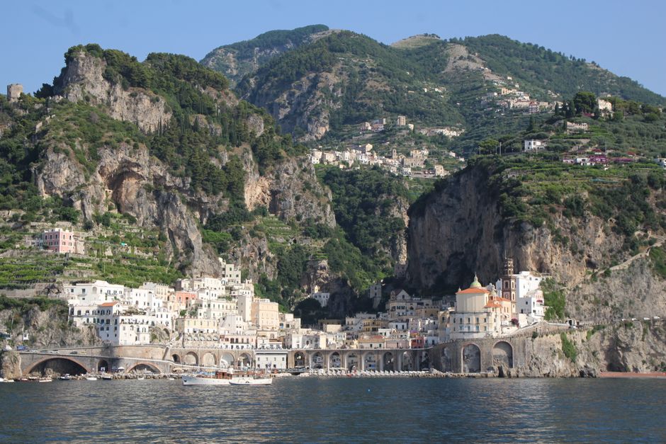 Pastel houses stacked above the sea on the Amalfi coast, Italy.