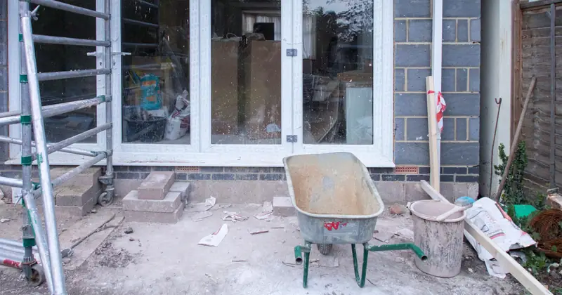 A construction site showcasing home renovation with scaffolding and tools.