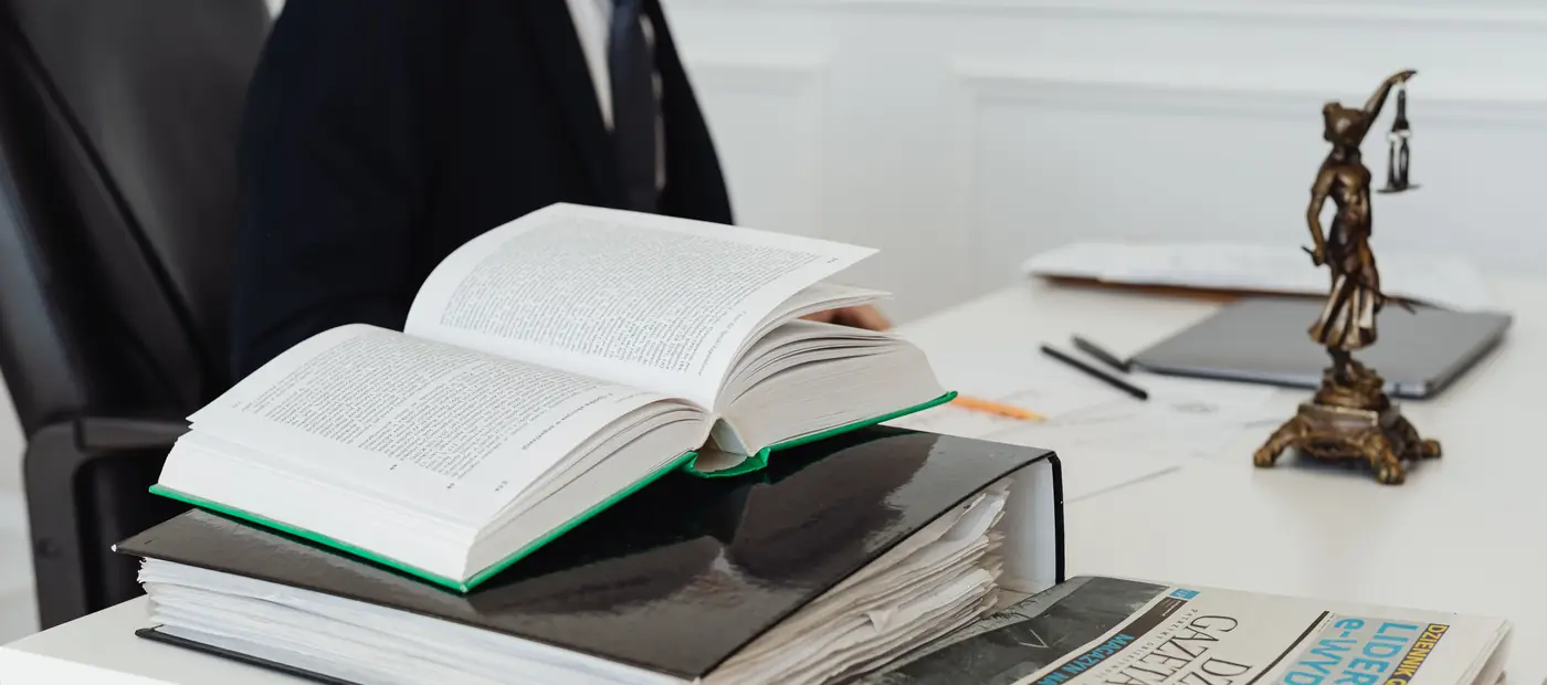 A lawyer sitting at a desk with legal books, documents, and a newspaper, embodying professionalism.