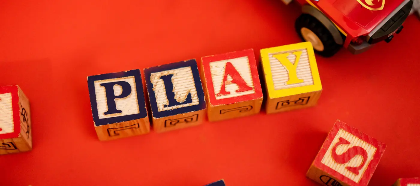 Top view of assorted wooden blocks spread on a wooden floor, creating a playful scene.