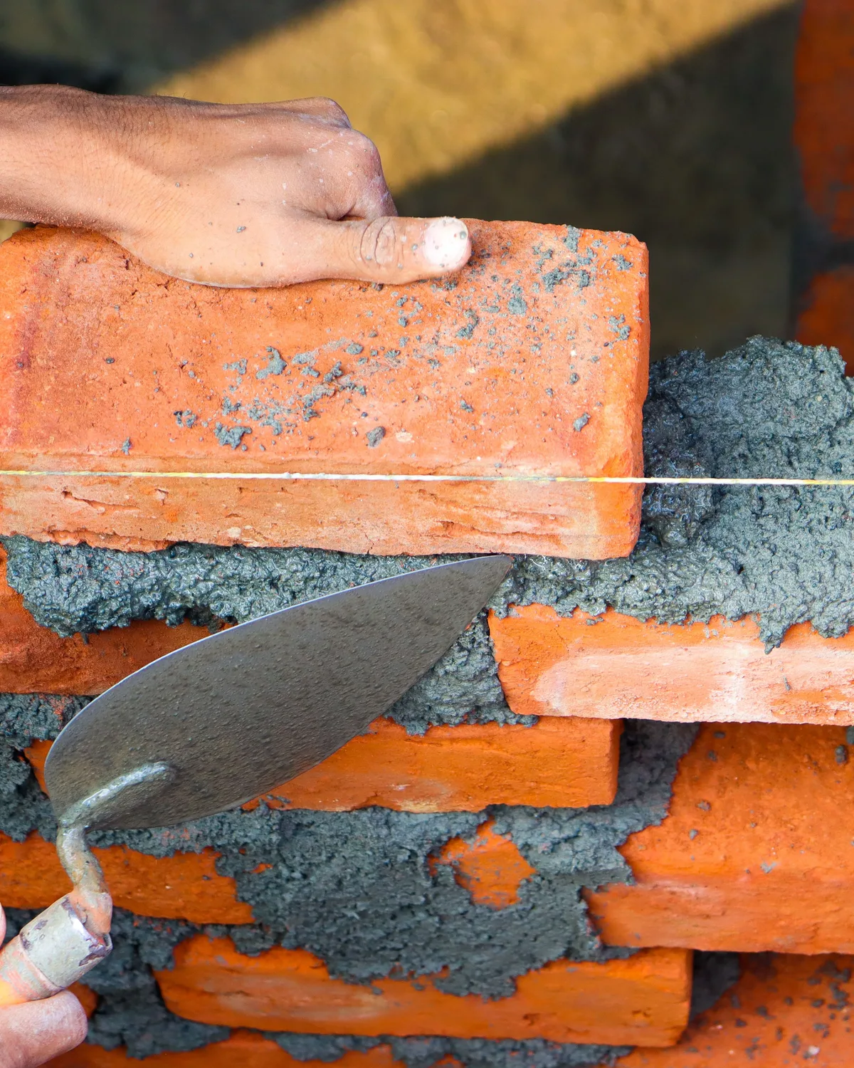 Representative stock image of a brick wall being built from reclaimed materials.