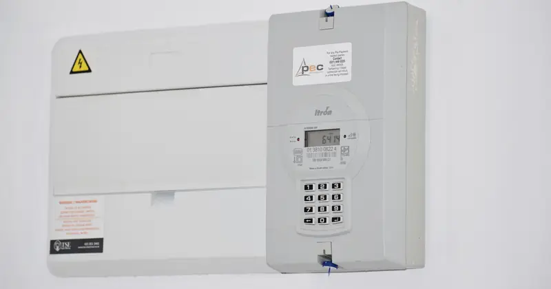 Electrical meter and fuse box on a white wall in Cape Town, South Africa, for energy monitoring or billing.
