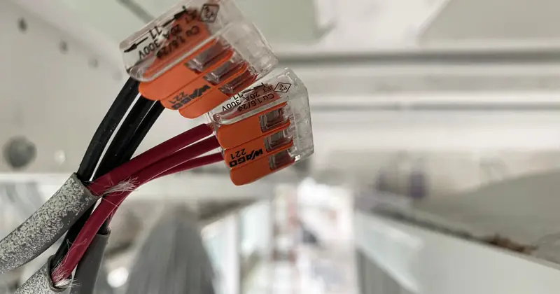 Detailed view of splicing connectors and wires in an indoor setting, ideal for technology-related projects.
