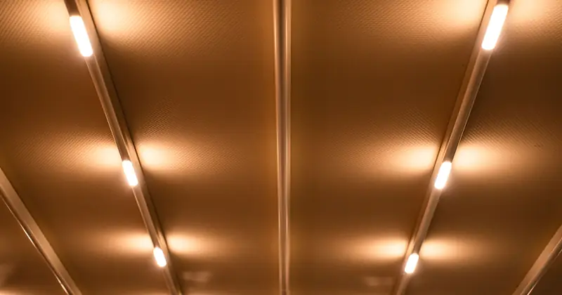 A minimalist ceiling with linear lights emitting a warm and inviting glow, creating a modern ambiance.