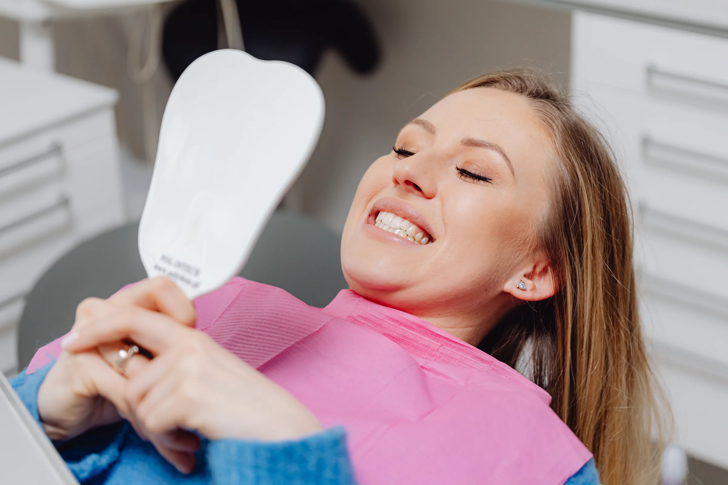 Smiling patient looking in a dental mirror